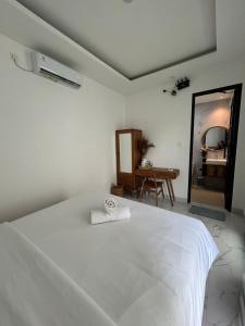 a bedroom with a white bed and a mirror at Kariarta Homestay in Cemagi