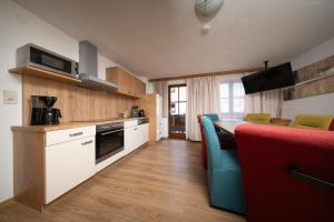 Una cocina con encimera, mesa y sillas. en Appartements Sonnenstein Sölden, close to lift & centre, en Sölden