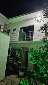 a green and white house with a balcony at Lugar Aconchecante in Palhoça