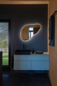 une salle de bain avec un lavabo et un miroir au mur dans l'établissement Holi Huus A und B, à Wallen