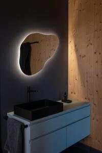 une salle de bain avec un lavabo noir et un miroir dans l'établissement Holi Huus A und B, à Wallen 41 autres photos