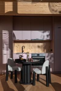 une cuisine avec une table, des chaises et un évier dans l'établissement Holi Huus A und B, à Wallen