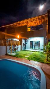 a house with a swimming pool in front of a house at Pousada Mon Gâté in Japaratinga
