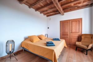 een slaapkamer met een bed en een stoel bij Casa Lounell, Piscine, Spa, Sauna in Graulhet +17 foto's