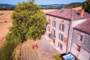 een uitzicht op een groot gebouw met een boom bij Casa Lounell, Piscine, Spa, Sauna in Graulhet