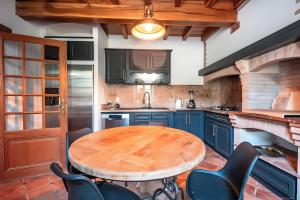 een keuken met een houten tafel en blauwe kasten bij Casa Lounell, Piscine, Spa, Sauna in Graulhet