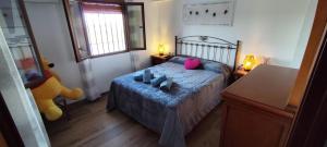 Un dormitorio con una cama con una manta azul y una ventana. en Casa Rural Emma, en Zuheros 34 fotos más