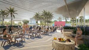 Een afbeelding van een resort met mensen die rond tafels zitten. bij Trendy Perge Resort & Suites in Aksu