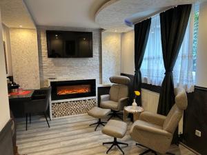 Leonardo's Sweet Hotel في Tappenbeck: غرفة معيشة بها موقد وكراسي ومكتب