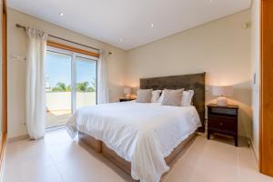 a bedroom with a large bed and a large window at Townhouse Sasha in Almancil +64 photos