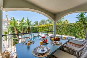 a table with food and drinks on a balcony at Townhouse Sasha in Almancil