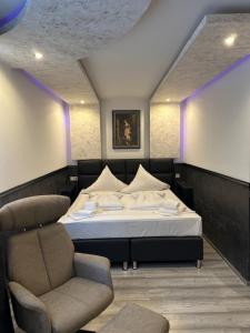 Leonardo's Sweet Hotel في Tappenbeck: غرفة نوم بها سرير وكرسي في الغرفة