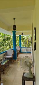 eine Veranda mit blauen Säulen und einem Tisch und Stühlen in der Unterkunft Amore Holiday Home in Canacona