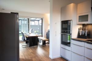 eine Küche mit Tisch und ein Esszimmer in der Unterkunft Haus Friesenkuss mit Hund in Wangerland