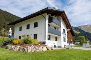 a large white building with a gambrel roof at Maurig Appartements in Elbigenalp