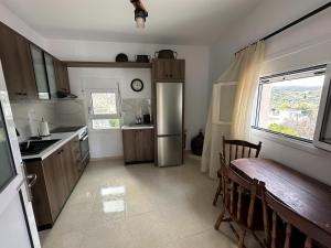 a kitchen with a stainless steel refrigerator and a window at Aski house - Authentic Cretan life by Hostinous in Askoí