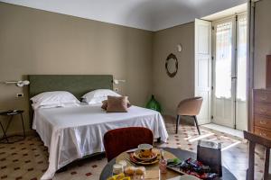 Casa dei Giurati في بالاتسولو أكريدي: غرفة نوم بسرير ابيض وطاولة