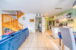 a living room with a blue couch and a kitchen at Bright house ideal for exploring Bordeaux in Bordeaux