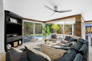 a living room with a couch and a tv at The Coastal Duo Escape in West Palm Beach