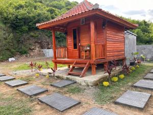 a small wooden cabin with a table in it at The Mawun Lombok in Selong Belanak