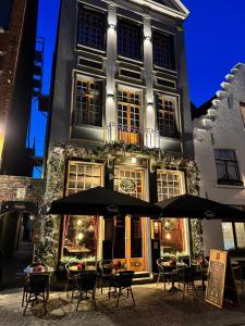 Un edificio con mesas y sombrillas delante. en Gran Hotel De Passage, en Brujas 150 fotos más