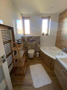 a bathroom with a tub and a toilet and a sink at Apartmán Jedľa pod Tatrami in Jezersko +15 photos