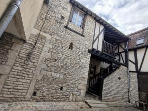 un vieux bâtiment en briques avec une fenêtre et un escalier dans l'établissement Les Gîtes Chez Léo, à Bar-sur-Aube