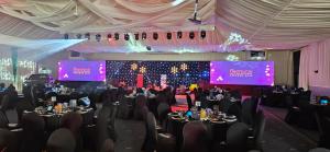 a banquet hall with tables and chairs and two screens at Holiday Inn Wolverhampton - Racecourse by IHG in Wolverhampton