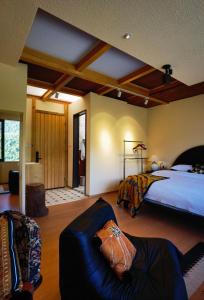 a bedroom with a bed and a couch in a room at Siguniang Mountain Lanxi Wild Luxury Hotel in Mount Siguniang