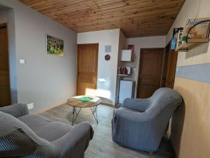 Una sala de estar con dos sillas y una mesa. en Chambre d'hôtes du Savernay, en Chantraine