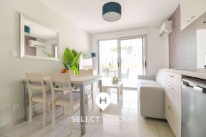 eine Küche und ein Esszimmer mit Tisch und Stühlen in der Unterkunft SELECT'soHOME - Résidence Le Poséidon - Piscine & Parking - Appartement pour 4 personnes - POS03 in Bormes-les-Mimosas + 5 Fotos