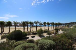 einen Park mit Palmen und einem Sandstrand in der Unterkunft SELECT'soHOME - Résidence Le Poséidon - Piscine & Parking - Appartement pour 4 personnes - POS03 in Bormes-les-Mimosas