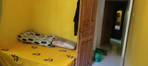 a room with a bed with a yellow wall at Arusha Holiday Safari in Arusha