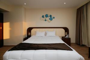 1 dormitorio con 1 cama blanca grande y reloj en la pared en Sahary Pyramids View Hotel, en Giza 34 fotos más