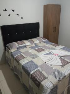 ポメロデにあるCanto dos Pássarosの壁に鳥が描かれたキルトが掛けられたベッド
