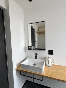 a bathroom with a white sink and a mirror at MOD 02 Kutchan Stylish Commons - NO PARKING 駐車場なし in Kutchan