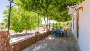 a patio with a table and chairs and trees at Cortijo El Llano Priego de Córdoba by Ruralidays in Priego de Córdoba