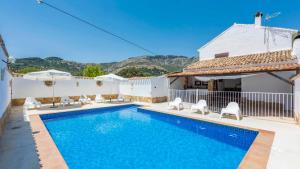 a swimming pool with chairs and a house at Cortijo El Llano Priego de Córdoba by Ruralidays in Priego de Córdoba