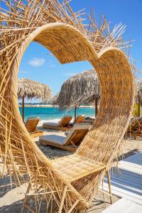 una sedia di paglia su una spiaggia con l'oceano di Elektra Comfort Hotel by Del Mare a Skala Prinos