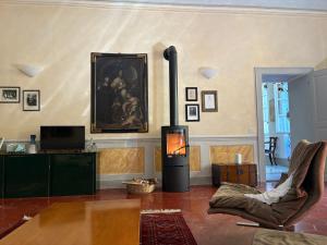 a living room with a fireplace and a chair and a painting at La Piscina nel Borgo in Bagnone