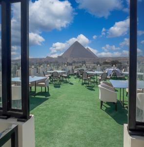 un restaurante con mesas y sillas y vistas a las pirámides. en Sahary Pyramids View Hotel, en Giza