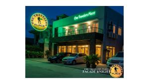 ein Gebäude mit davor geparkten Autos in der Unterkunft One Travelers Place in Koronadal