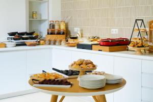 un tavolo con piatti e pasticcini sopra in una cucina di Elektra Comfort Hotel by Del Mare a Skala Prinos Altre 108 foto