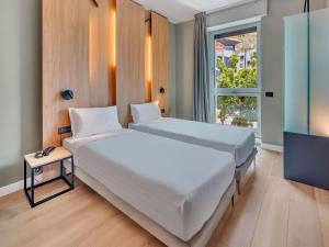 um quarto com uma grande cama branca e uma televisão em B&B HOTEL Milano Portello em Milão