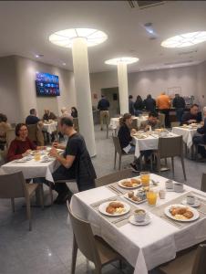 Hotel SoleMare في ديانو مارينا: مجموعة من الأشخاص يتناولون الطعام على الطاولات في مطعم