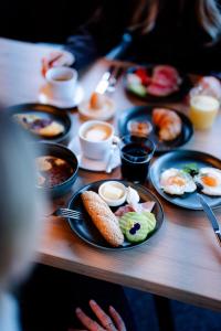 a table with plates of breakfast food on it at LH Linzerhaus Suites Saalbach - inklusive Jokercard in Saalbach-Hinterglemm