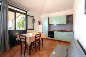 een keuken en eetkamer met een tafel en stoelen bij Domus de Goene in Loceri