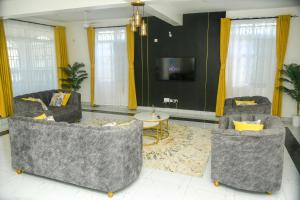 a living room with two couches and a tv at Leah's Luxury Villa in Mombasa