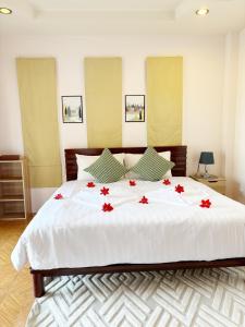 a bedroom with a large white bed with red flowers on it at Sachi Home Villa Bangtao - Near Muay Thai and Beach in Ban Thalat Choeng Thale