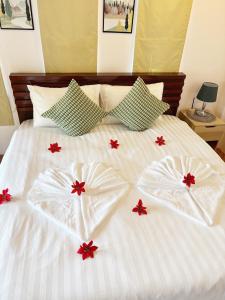 a white bed with red flowers on top of it at Sachi Home Villa Bangtao - Near Muay Thai and Beach in Ban Thalat Choeng Thale